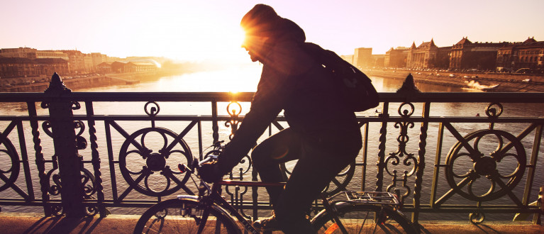 Man op een fiets fietst over een brug