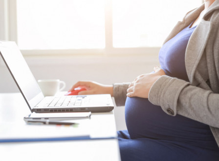 Zwangere vrouw aan het werk achter laptop